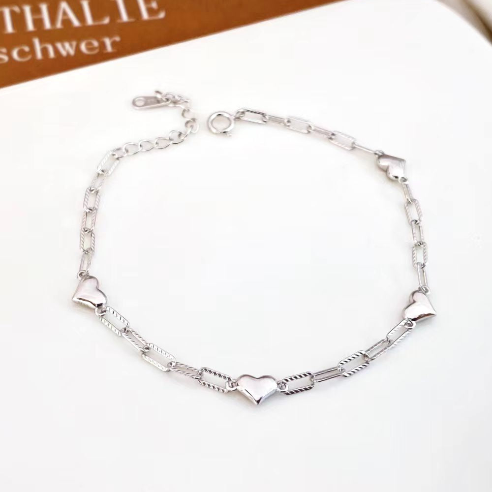 This charming sterling silver bracelet features an elegant combination of heart and link designs. The rhodium plating adds a sleek, polished finish and helps prevent tarnishing, ensuring lasting beauty.
