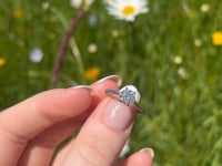 A beautiful continuum silver one  carat round brilliant moissanite ring, displaying the rainbow fire that is unique to this unique gemstone. This video has been shot in a field with wild flowers and you can hear the birds and wildlife in the back ground.