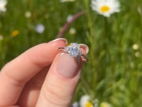 A beautiful continuum silver one and a half carat oval brilliant moissanite ring, displaying the rainbow fire that is unique to this unique gemstone. This video has been shot in a field with wild flowers and you can hear the birds and wildlife in the back ground.