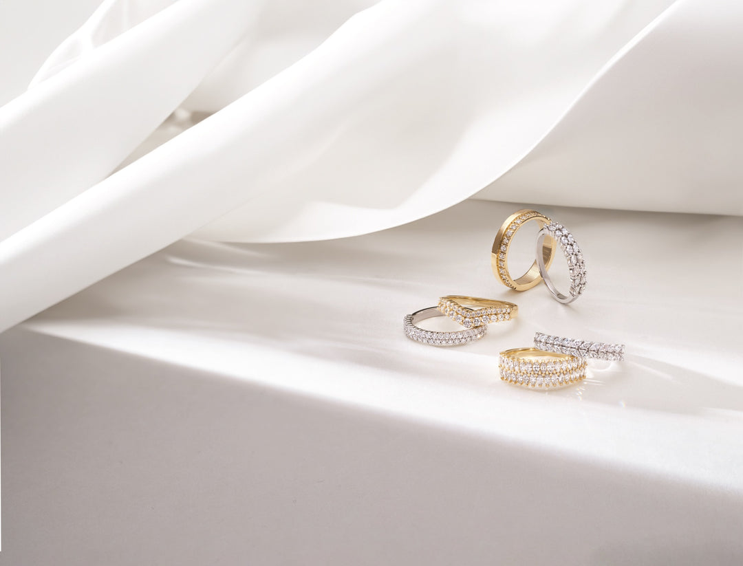 beautiful wedding and anniversary rings crafted from recycled gold and lab grown diamonds in a lovely setting with soft lighting and delicately draped material