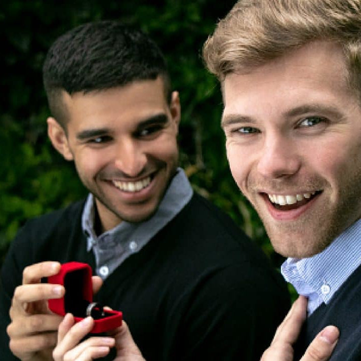 A gay couple, men, have just got engaged and are very happy with a ring box and engagement ring