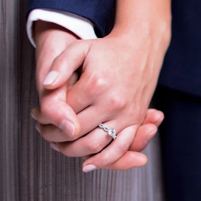 A couple holding hands, with the woman wearing a beautiful Engagement Ring