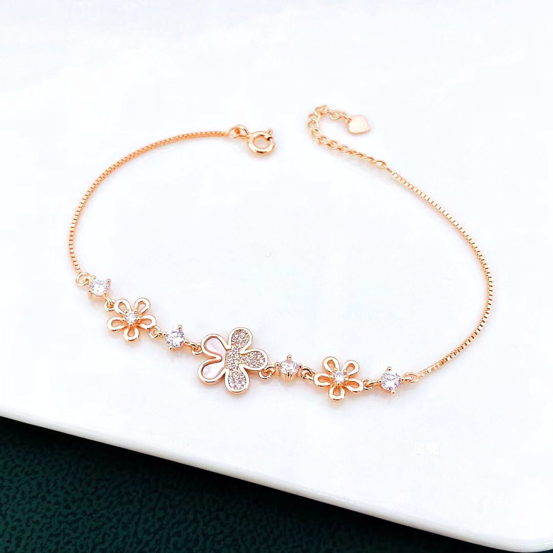 Add a touch of charm to your jewellery collection with this delightful flower-themed rose gold-plated sterling silver bracelet. Crafted with a delicate chain, this piece features enchanting flower accents adorned with sparkling cubic zirconia stones. The combination of intricate floral designs and dazzling stones creates a whimsical yet elegant look.