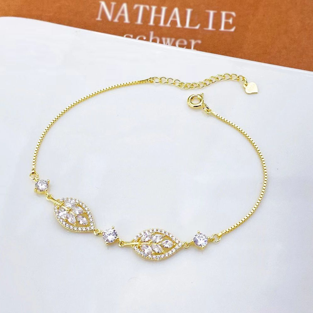 Add a touch of sophistication with this stunning sterling silver bracelet. Crafted with a delicate chain and adorned with sparkling cubic zirconia stones, this piece embodies timeless elegance. The centrepiece features two marquise-cut zirconia stones framed by a halo of smaller, round-cut stones, creating a captivating sparkle with every movement.