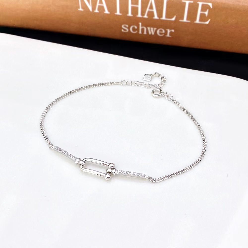 This chic sterling silver bracelet features a modern geometric design adorned with sparkling cubic zirconia stones. The rhodium plating adds a sleek, elegant touch and helps prevent tarnishing, ensuring long-lasting beauty.  Material: Premium sterling silver with rhodium pla