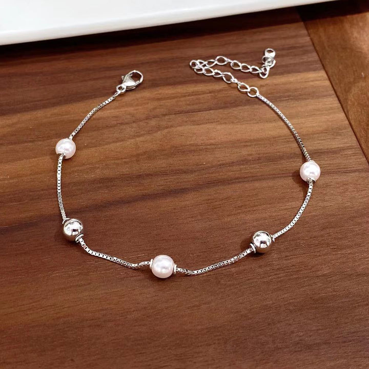 This elegant sterling silver bracelet features alternating pearls and polished silver beads. The rhodium plating adds a sleek, sophisticated touch and helps prevent tarnishing, ensuring lasting beauty.