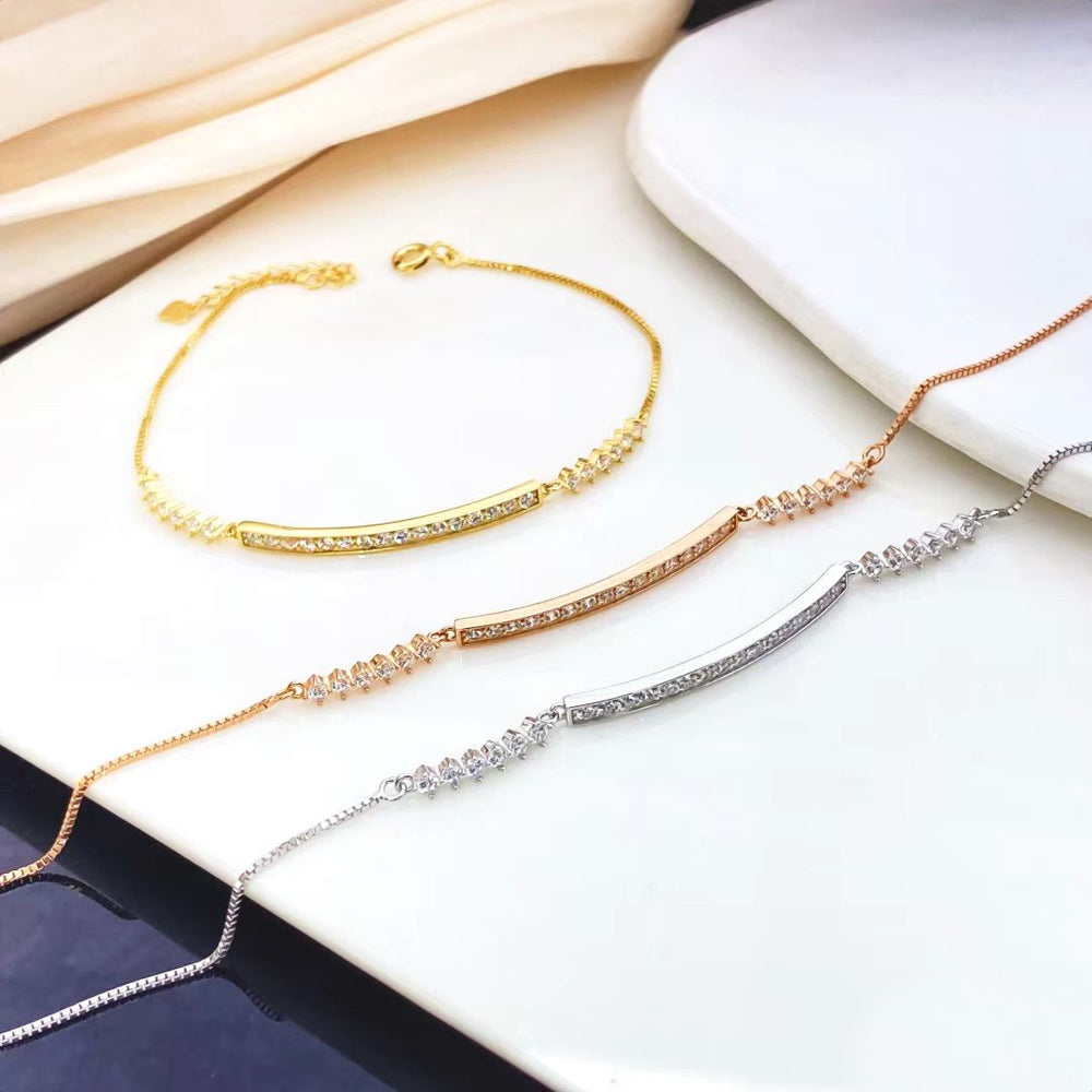 This elegant sterling silver bracelet features a sleek bar design adorned with sparkling cubic zirconia stones. The yellow gold plating adds a luxurious touch and helps prevent tarnishing, ensuring lasting beauty.