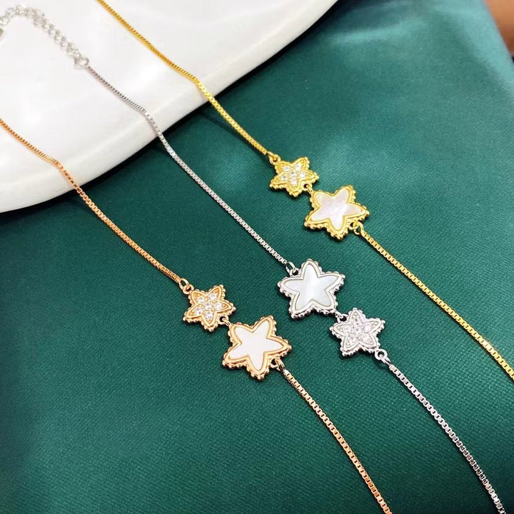 This delightful sterling silver bracelet features charming star-shaped designs, one adorned with sparkling cubic zirconia and the other with a lustrous mother of pearl inlay. The yellow gold plating adds a touch of elegance and helps prevent tarnishing, ensuring long-lasting beauty.