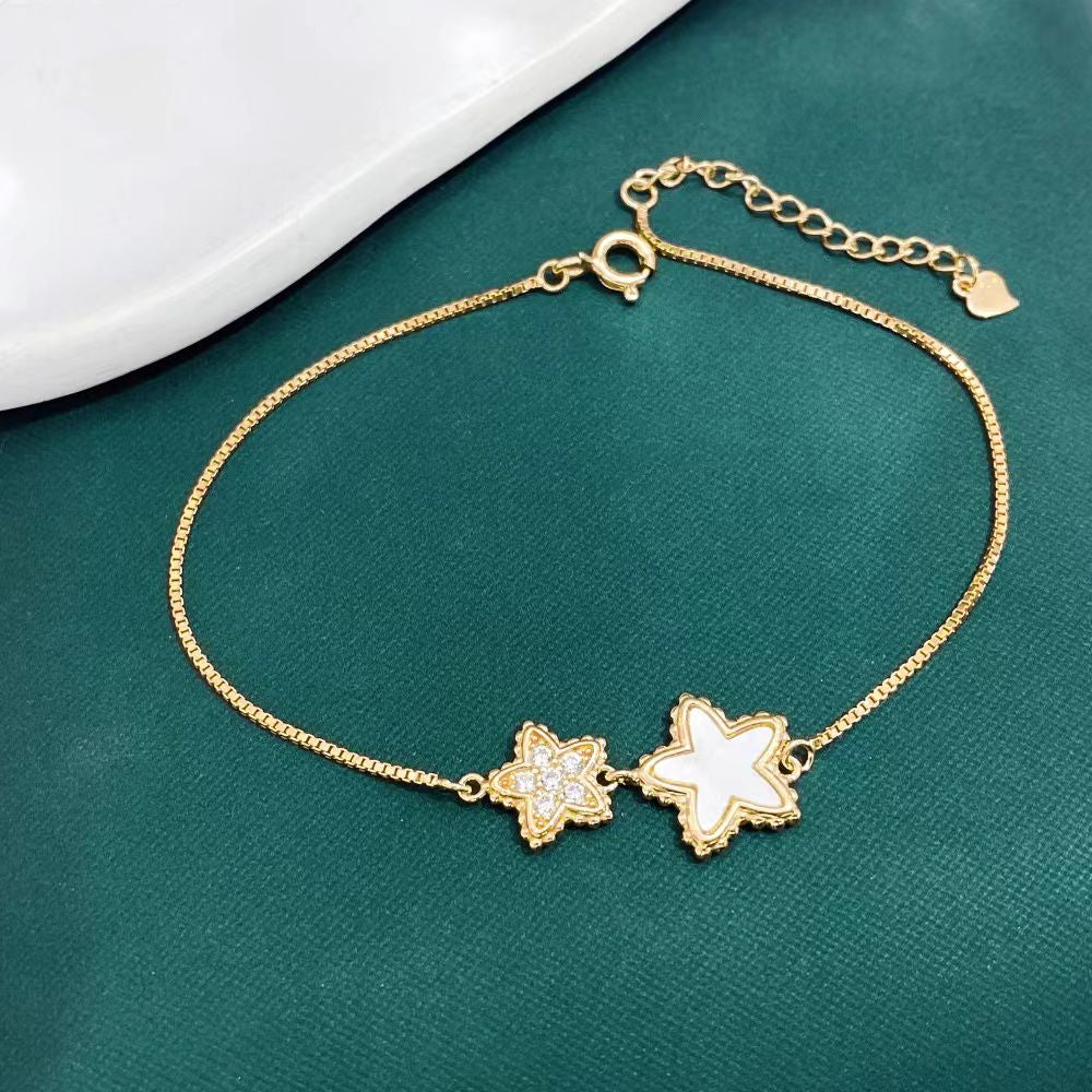 This delightful sterling silver bracelet features charming star-shaped designs, one adorned with sparkling cubic zirconia and the other with a lustrous mother of pearl inlay. The yellow gold plating adds a touch of elegance and helps prevent tarnishing, ensuring long-lasting beauty.