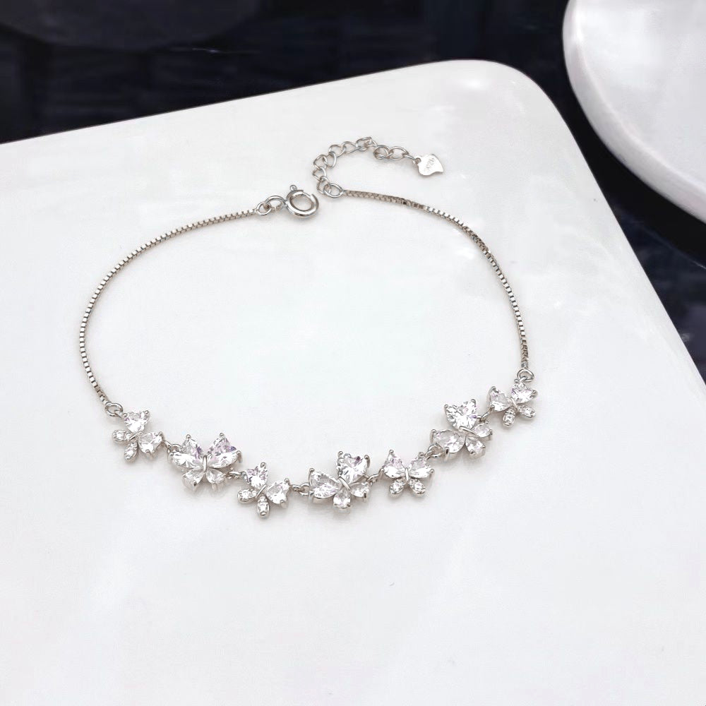 Enhance your elegance with this stunning sterling silver bracelet adorned with a delicate heart-shaped cubic zirconia set into a bow design. Each stone is meticulously set to form charming bows that catch the light with every movement. The intricate design and sparkling accents make this piece a timeless addition to any jewellery collection.