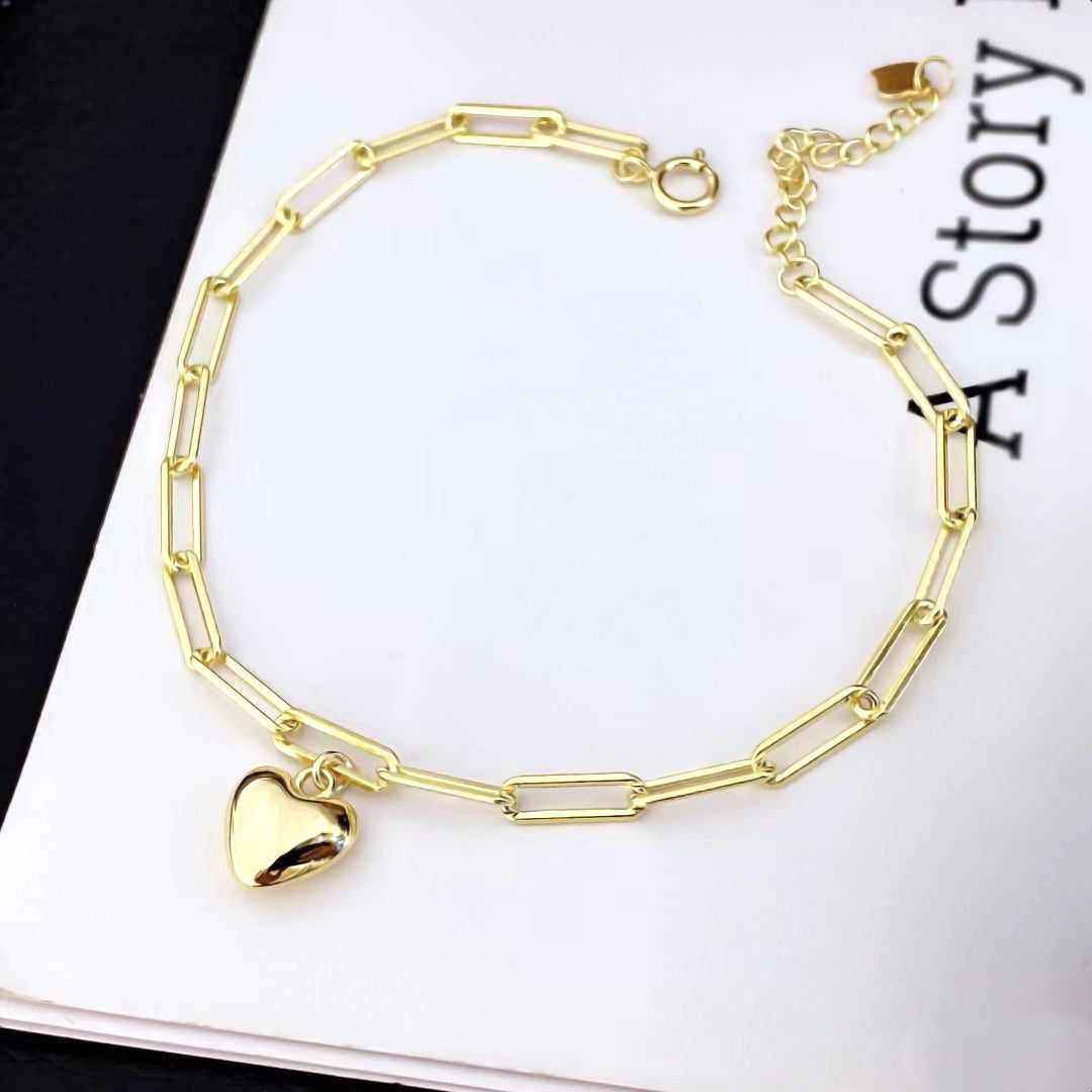 Embrace modern elegance with this chic heart charm bracelet. Crafted from premium sterling silver and plated in gold, this bracelet features a stylish paperclip chain design with a single, polished heart charm. The contemporary look and versatile design make it a perfect accessory for any occasion.