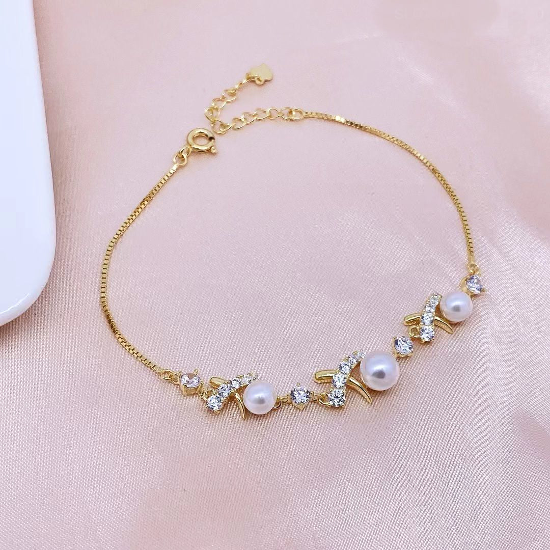 Add a touch of luxury to your jewellery collection with this exquisite gold-plated sterling silver bracelet. Featuring a delicate chain, this piece is adorned with lustrous pearls and sparkling cubic zirconia stones, creating a sophisticated and timeless look. The elegant design and shimmering accents make it perfect for any occasion.