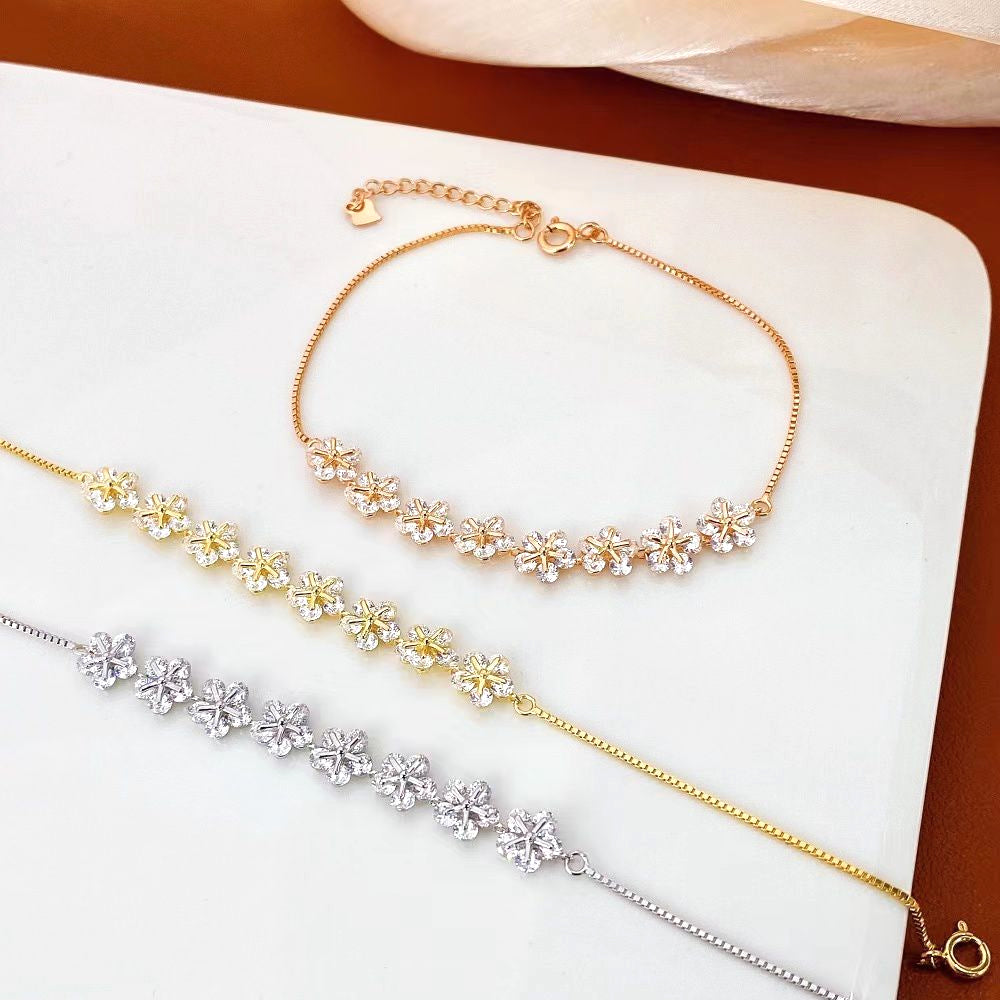 This charming sterling silver bracelet features delicate floral designs with sparkling cubic zirconia stones. The yellow gold plating adds a touch of elegance and helps prevent tarnishing, ensuring long-lasting beauty.