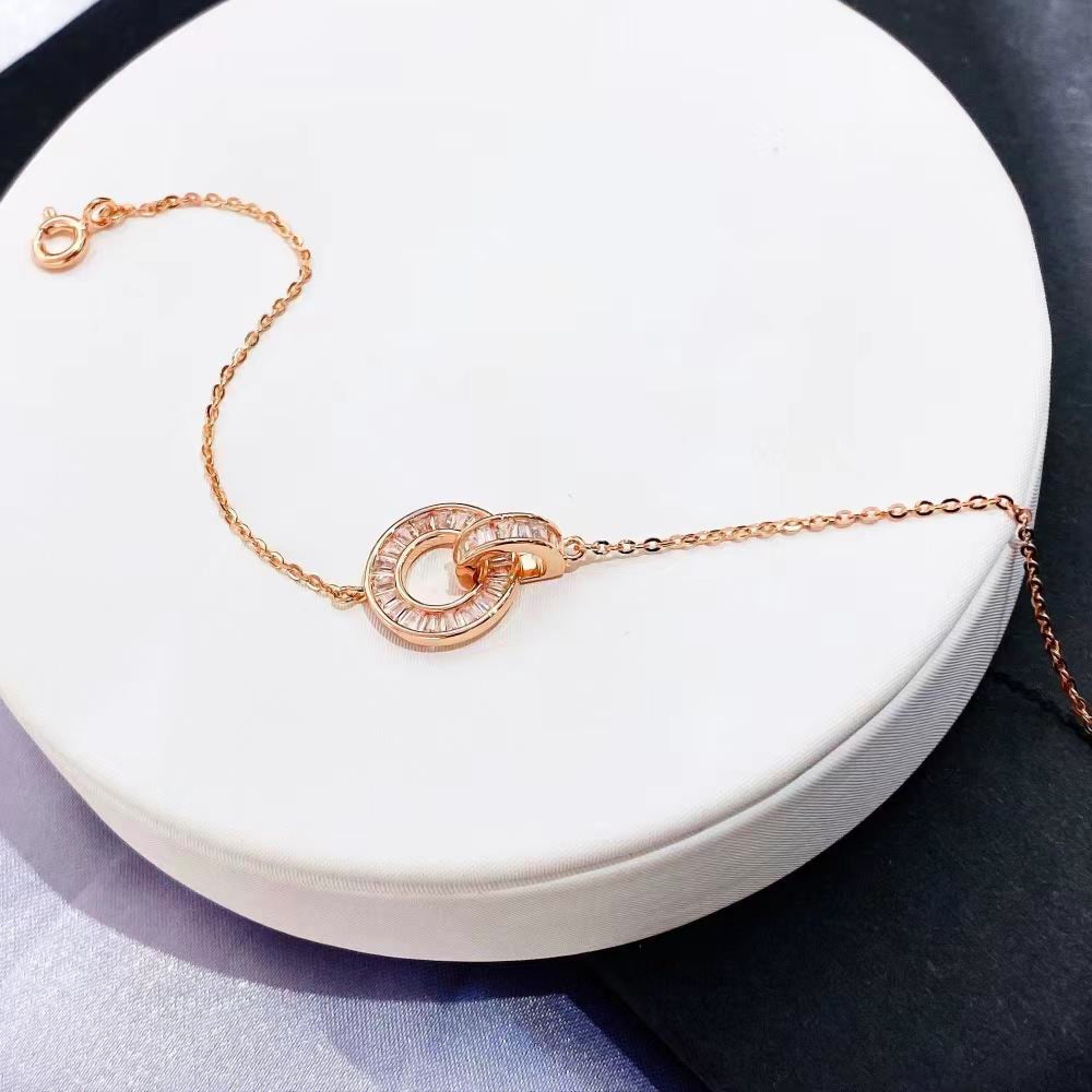 Add a touch of modern elegance to your jewellery collection with this beautiful interlocking circle bracelet. Crafted from rose gold-plated sterling silver, this delicate piece features two interlocking circles adorned with sparkling cubic zirconia stones. The contemporary design and shimmering accents make it a perfect accessory for any occasion.