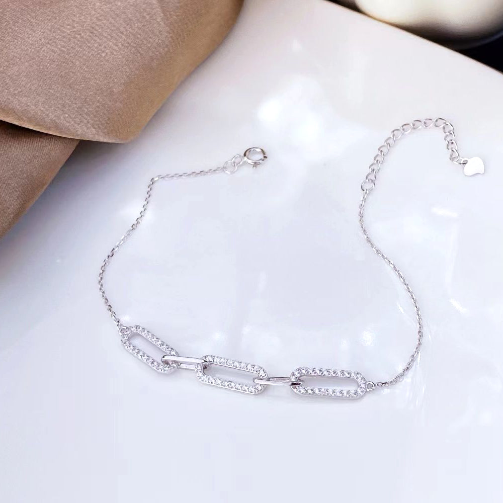 Add a touch of contemporary elegance to your jewellery collection with this exquisite link bracelet. Crafted from premium sterling silver, this piece features modern, rectangular links adorned with sparkling cubic zirconia stones. The sleek design and shimmering accents make it a perfect accessory for any occasion.