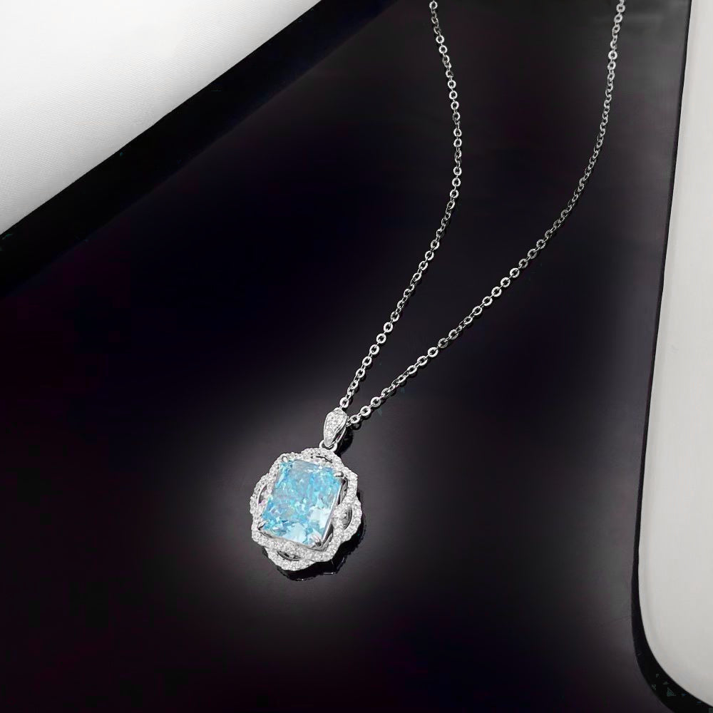 This sterling silver necklace boasts a brilliant sky blue nano crystal, admired for its exceptional sparkle and vibrant colour. Encased in an intricately designed rhodium-plated frame adorned with shimmering cubic zirconia, this piece adds a touch of refined elegance to any ensemble.